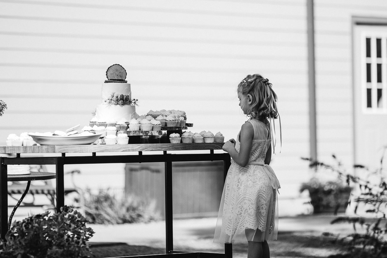 Flower girl looking at wedding cake