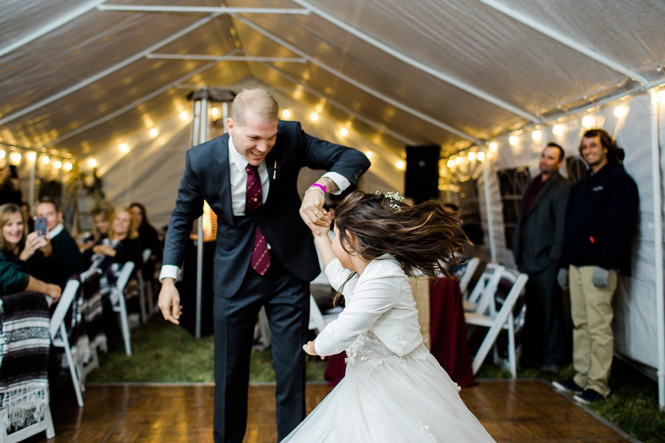 Groom dancing with daughter at wedding