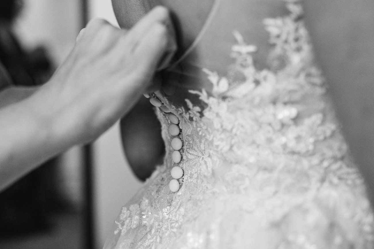 buttoning up bride's dress