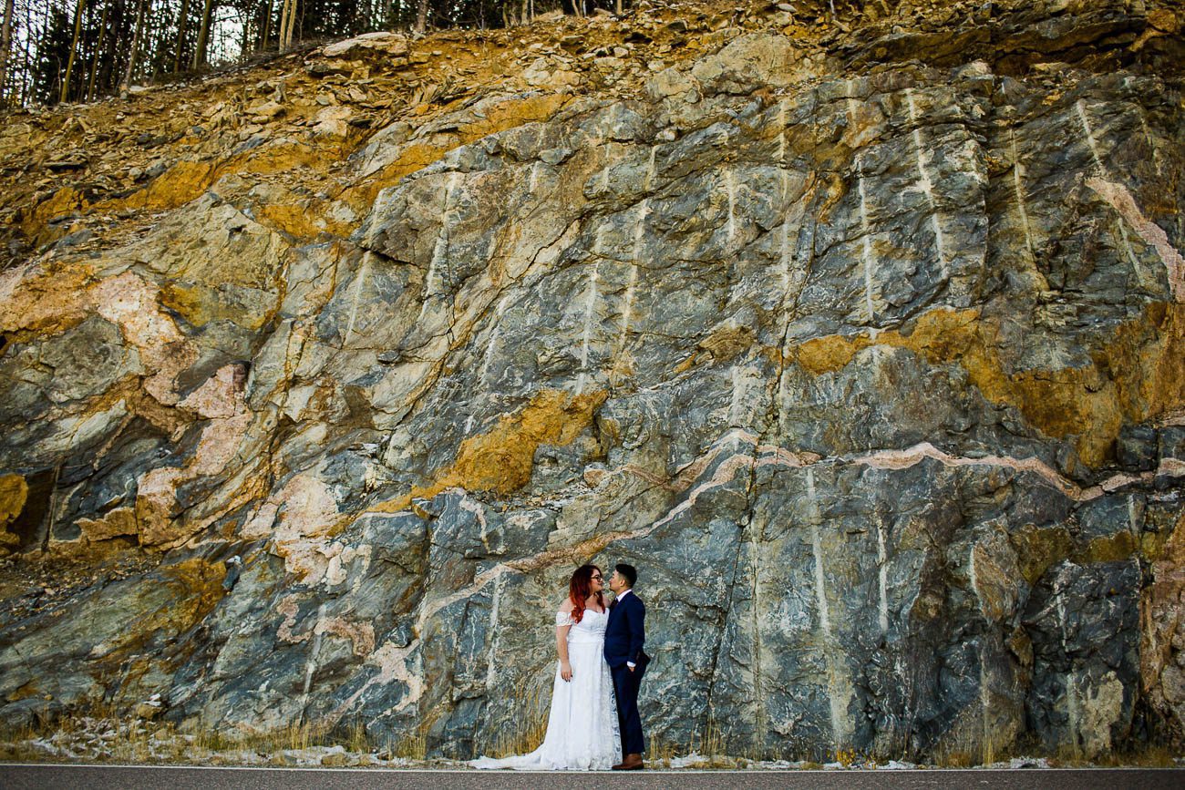 Wedding photo in front of rock wall
