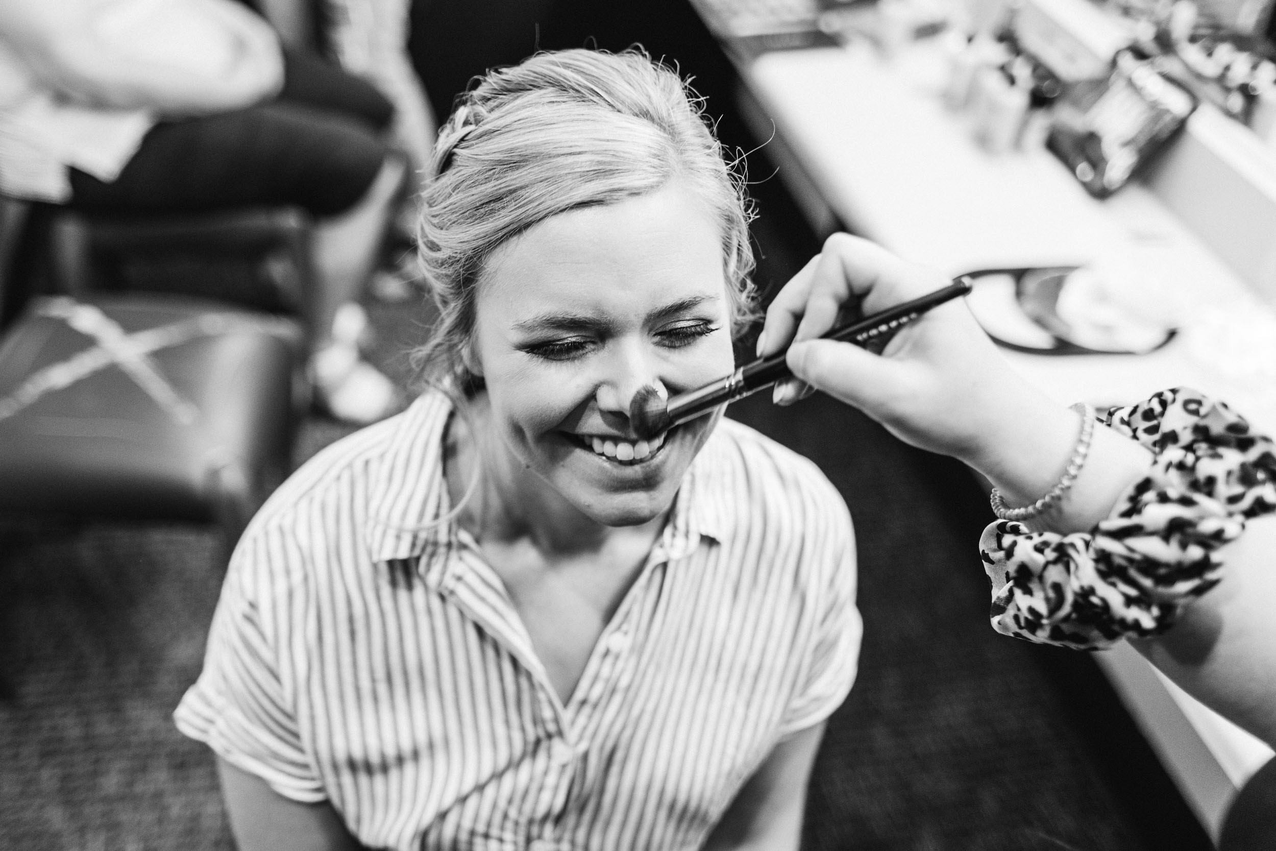 bride getting makeup done before wedding