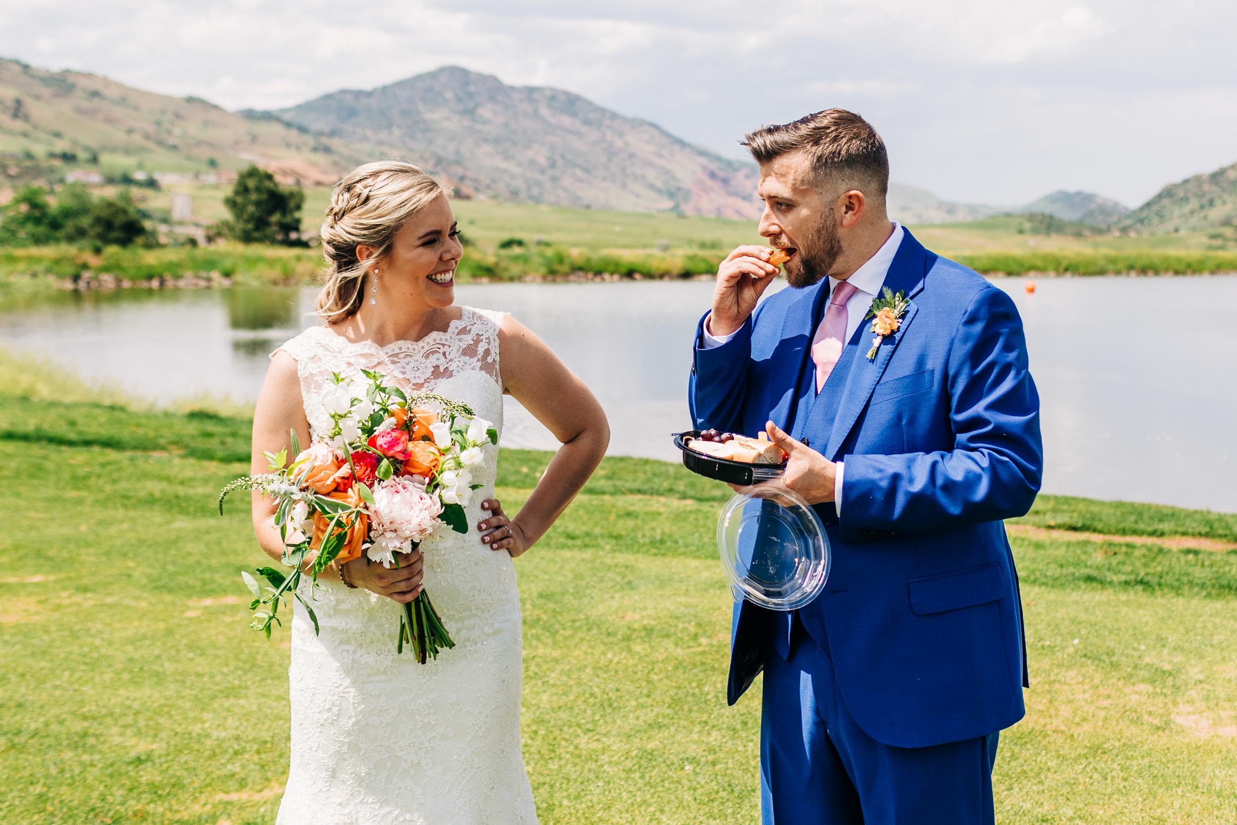 groom eating while bride smiles at him by Shea McGrath Photography Denver Colorado Wedding Photographer