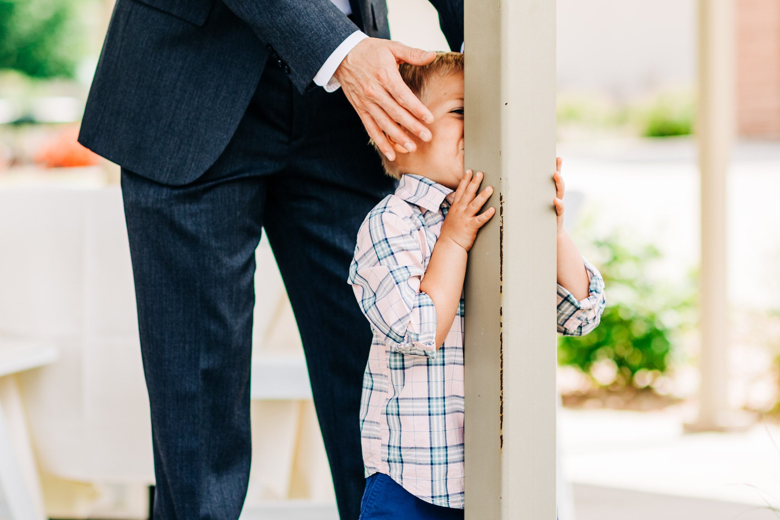 ring bearer hiding behind pole by Shea McGrath Photography Denver Colorado Wedding Photographer