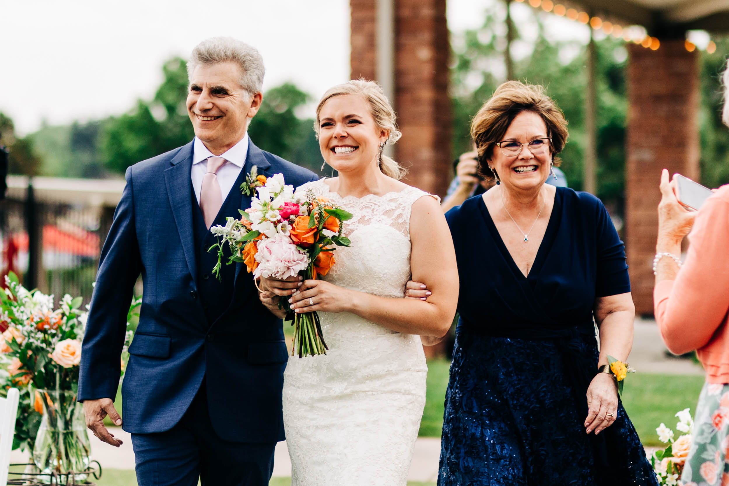 bride and parents smiling while bride walks down aisle by Shea McGrath Photography Denver Colorado Wedding Photographer