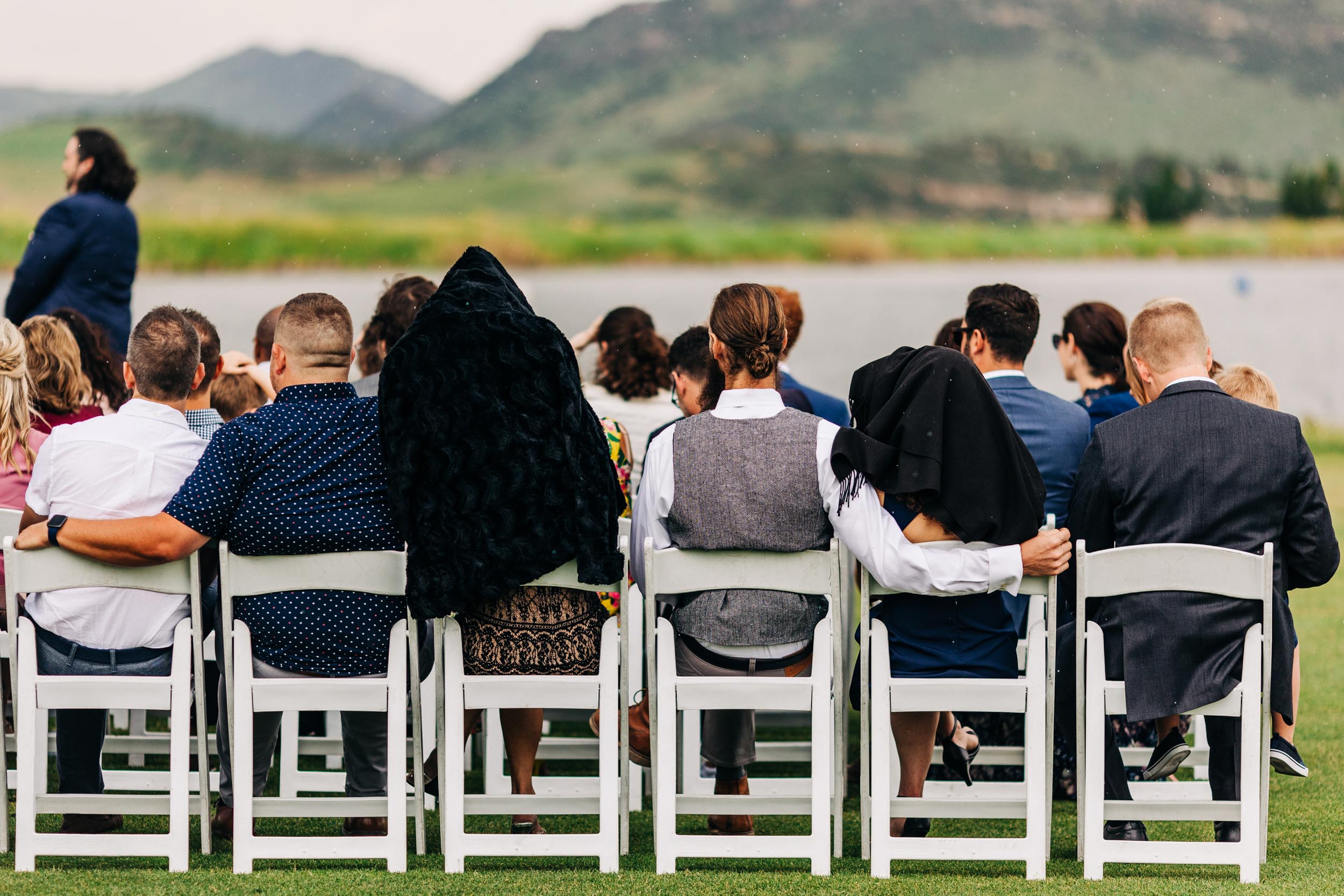 guests covering their heads during rainy wedding ceremony by Shea McGrath Photography Denver Colorado Wedding Photographer