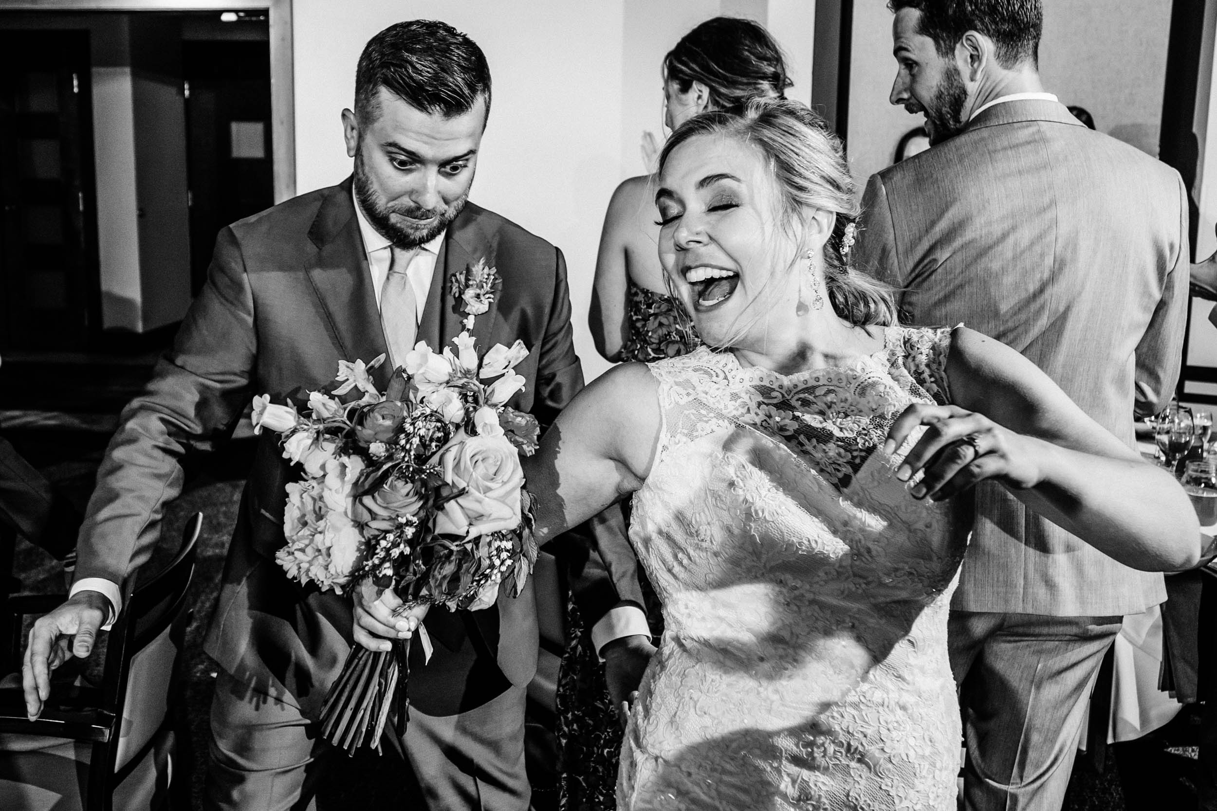 groom tripping on bride's dress during reception entrance by Shea McGrath Photography Denver Colorado Wedding Photographer