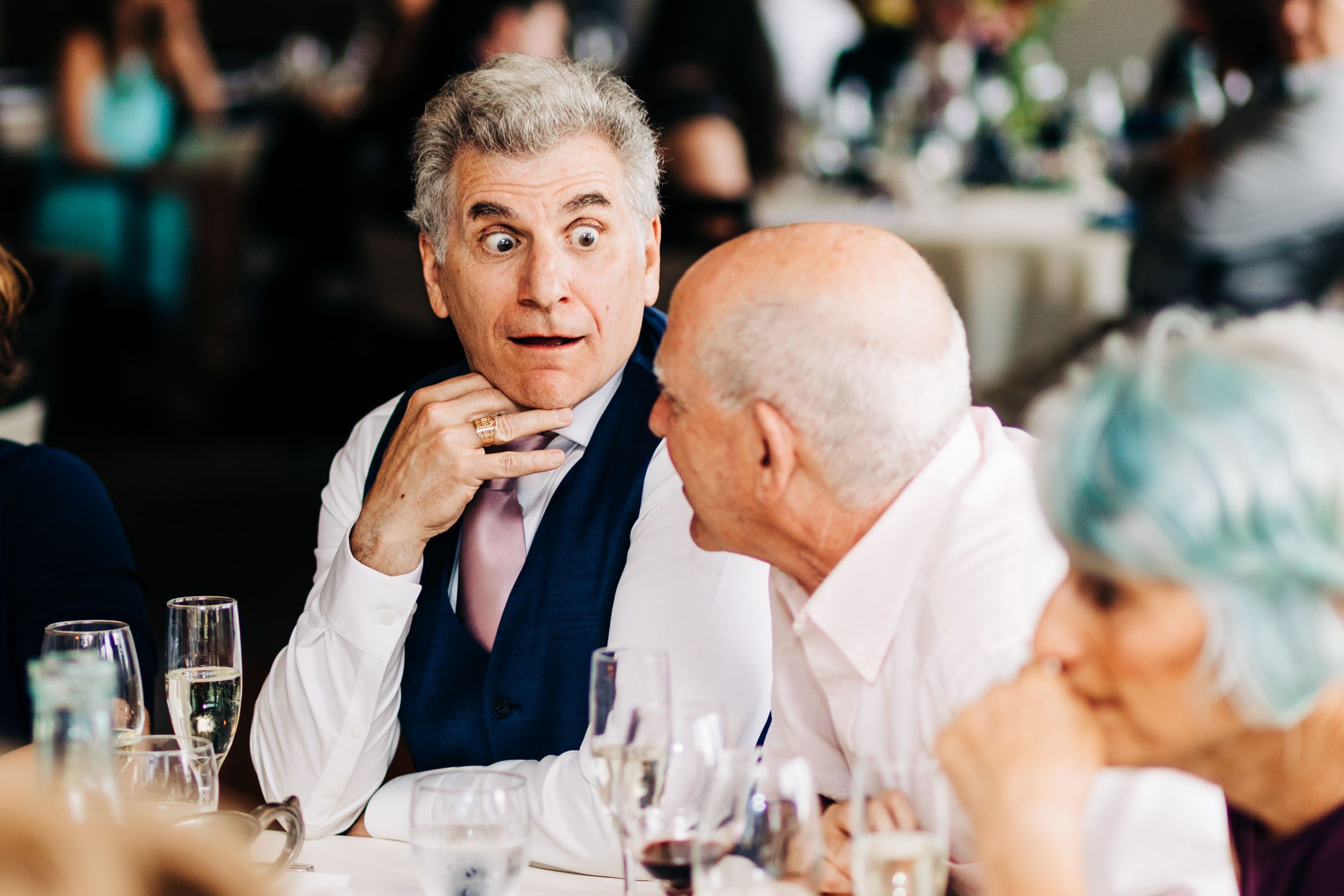 guest making dramatic reaction while talking to other guest at wedding by Shea McGrath Photography Denver Colorado Wedding Photographer