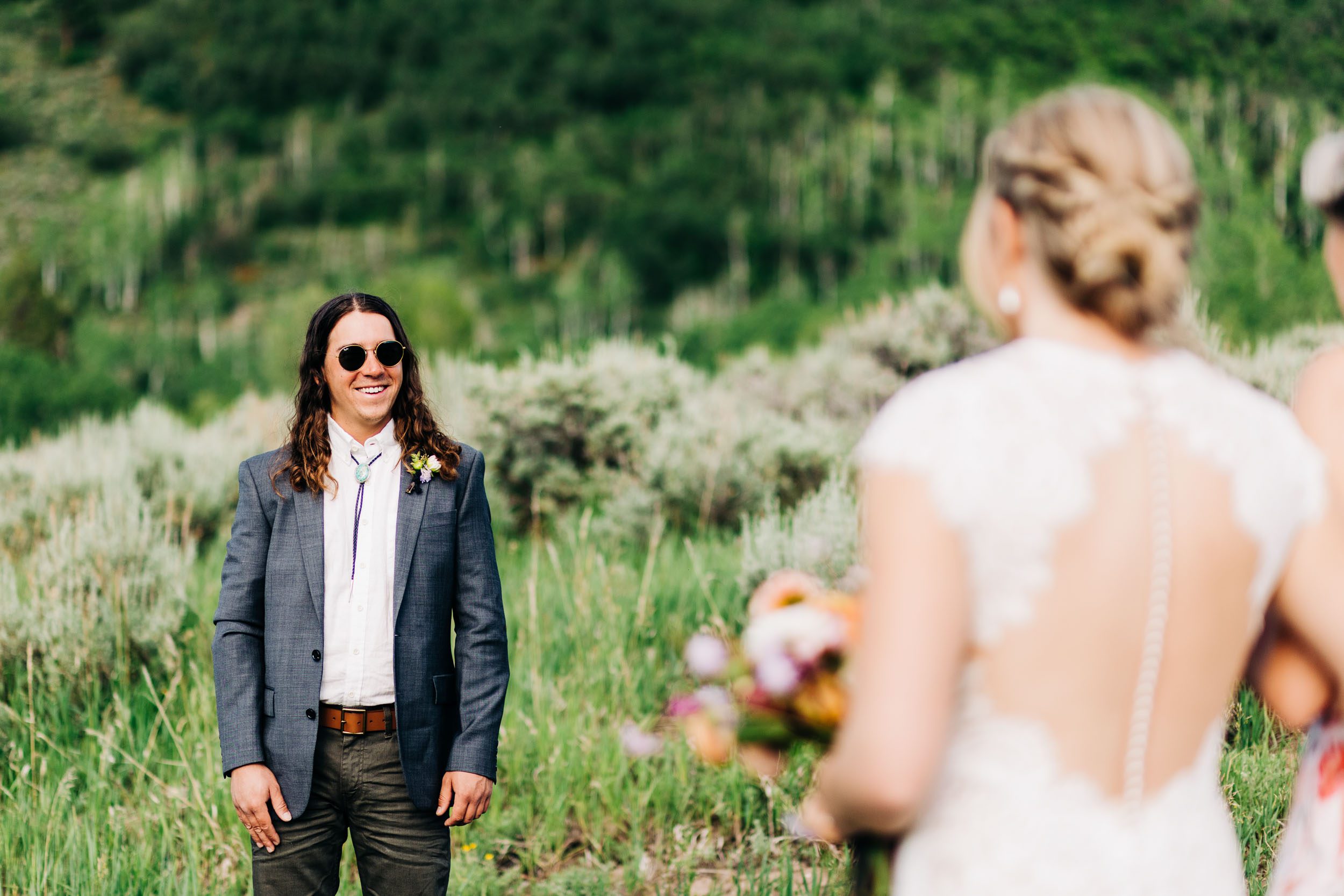 Groom watching bride walk down aisle