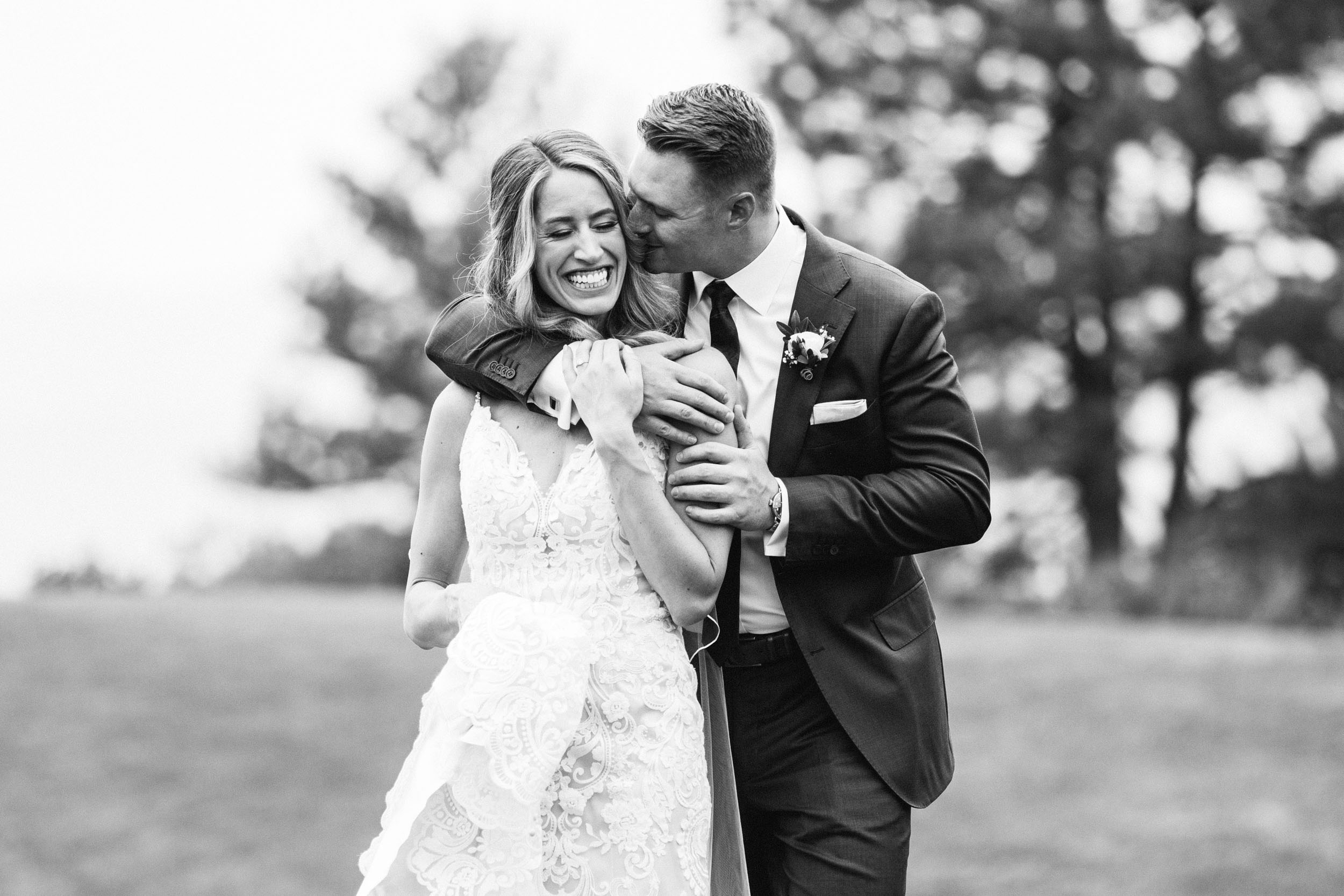 groom hugging bride wedding portraits