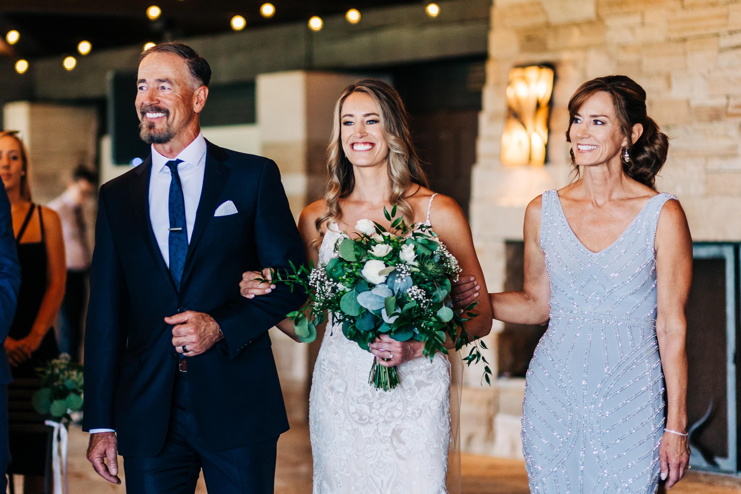 bride walking down aisle with parents at sanctuary golf course wedding in Colorado