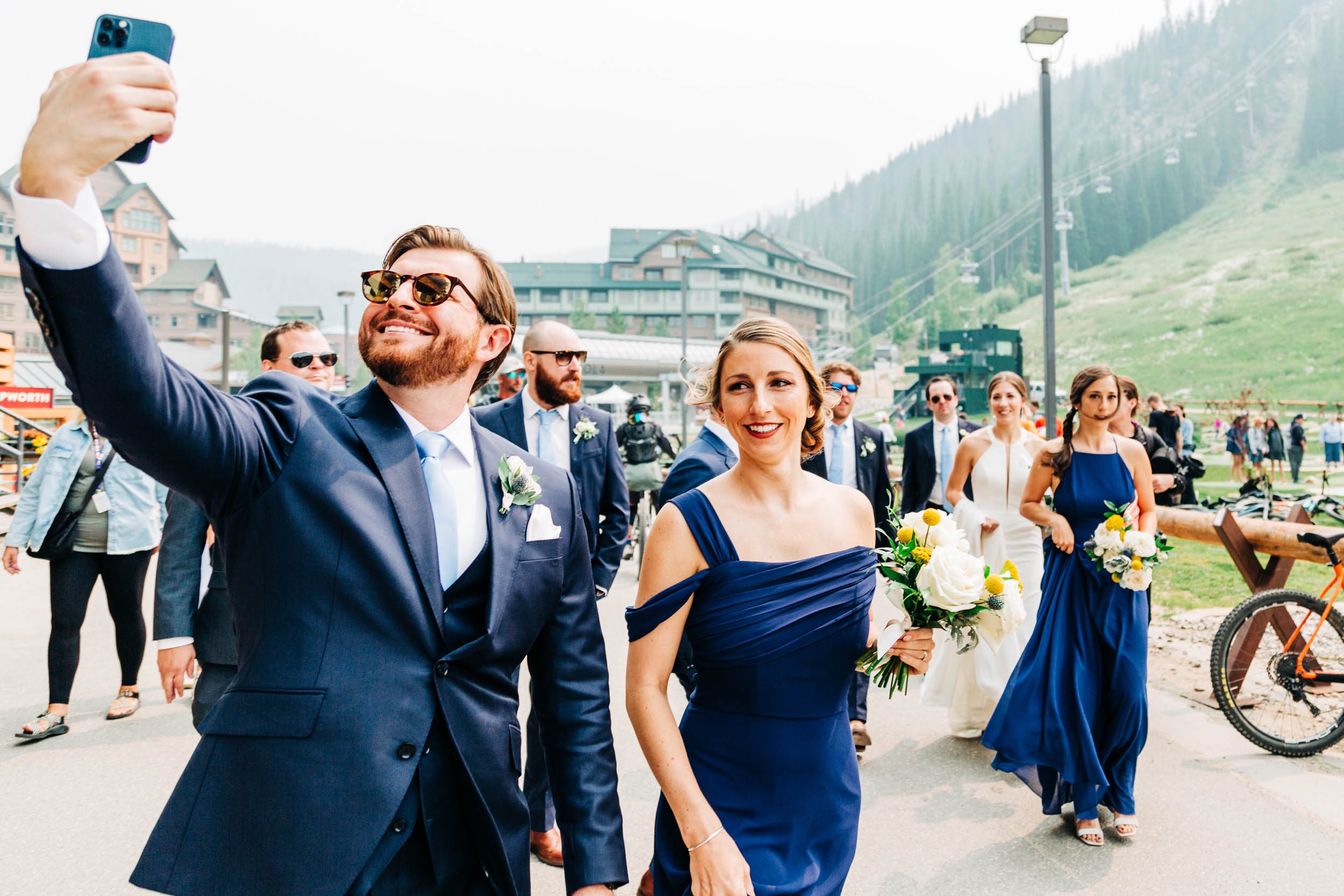 Wedding party walking to ski lift at winter park resort