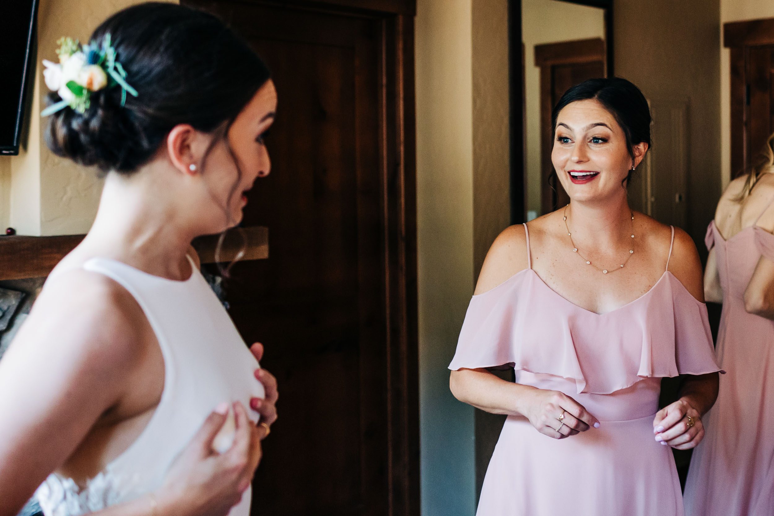 Bride and bridesmaid laughing during getting ready