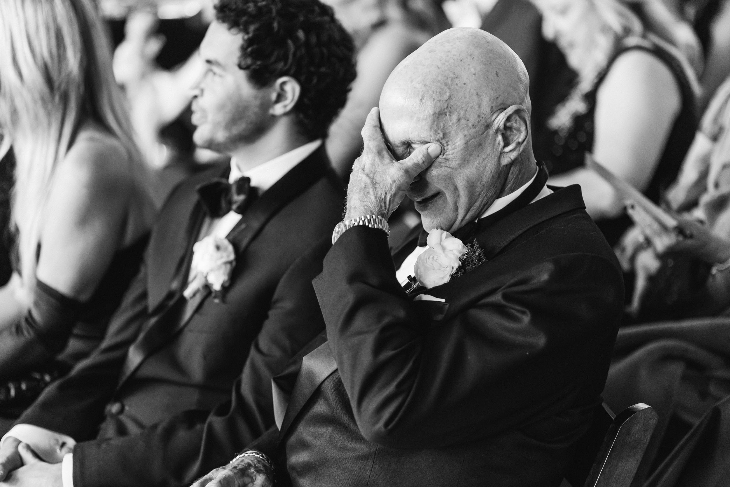 father of the bride wiping eyes during ceremony