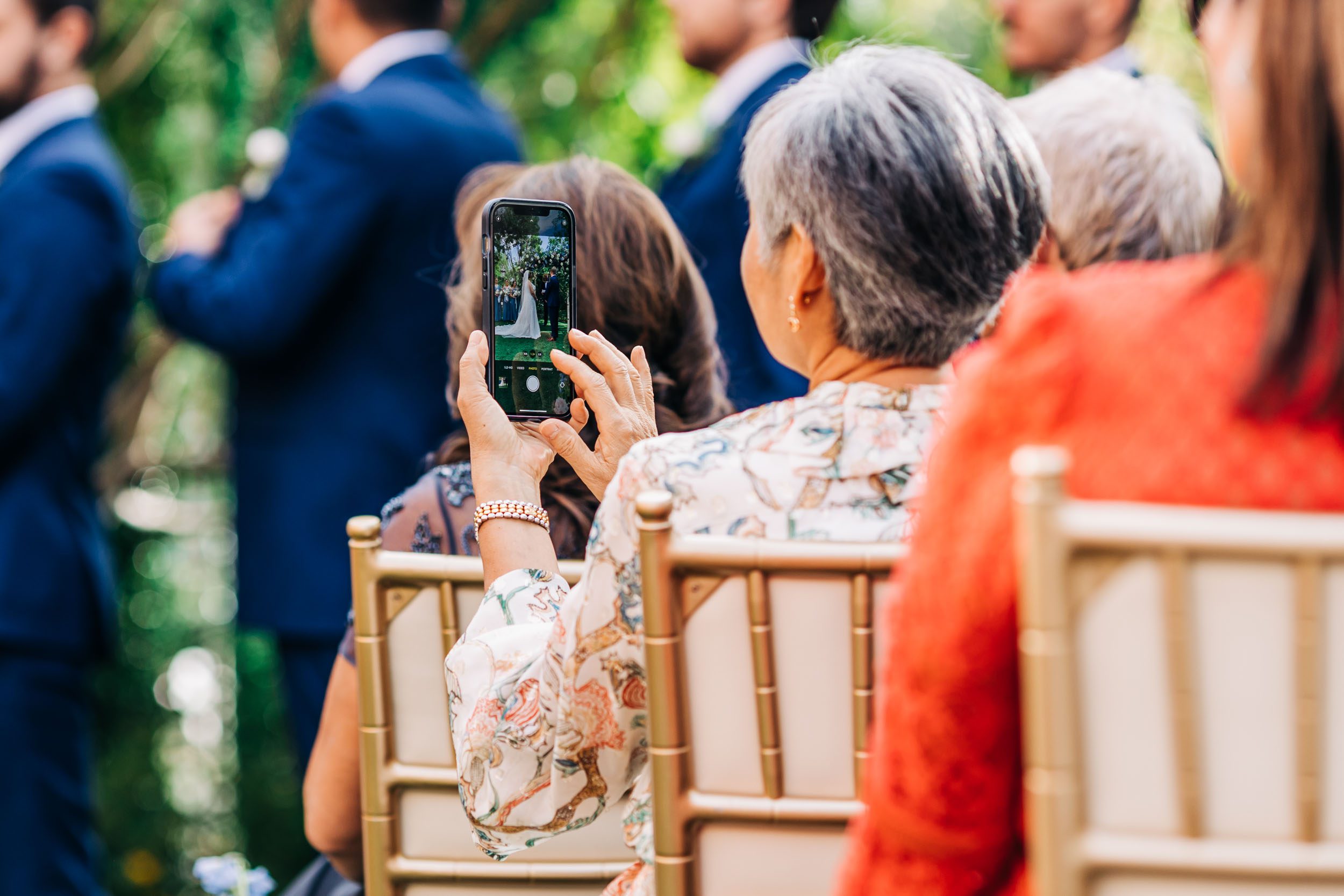 guest taking photo of wedding on her phone