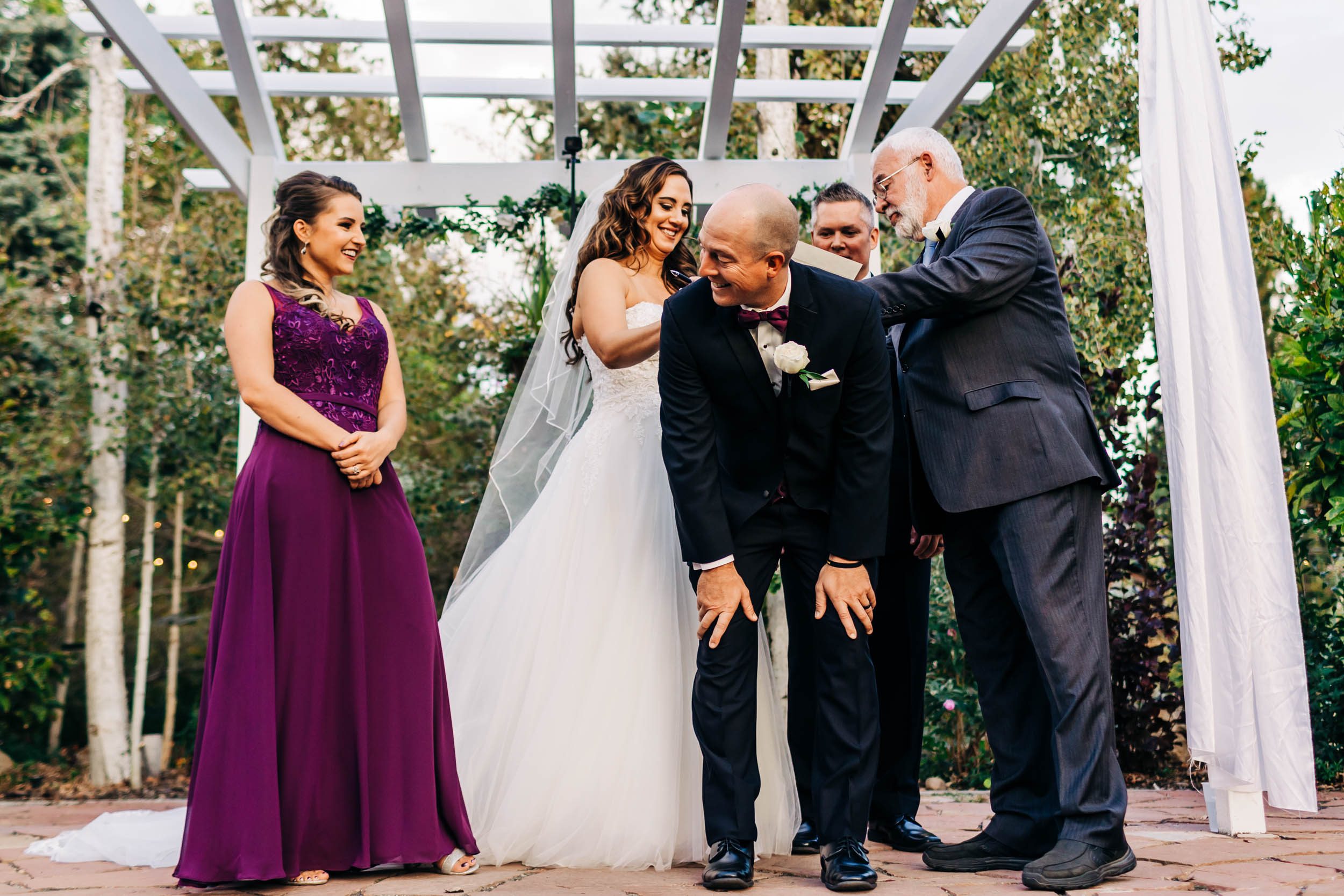 signing marriage license on groomsman's back