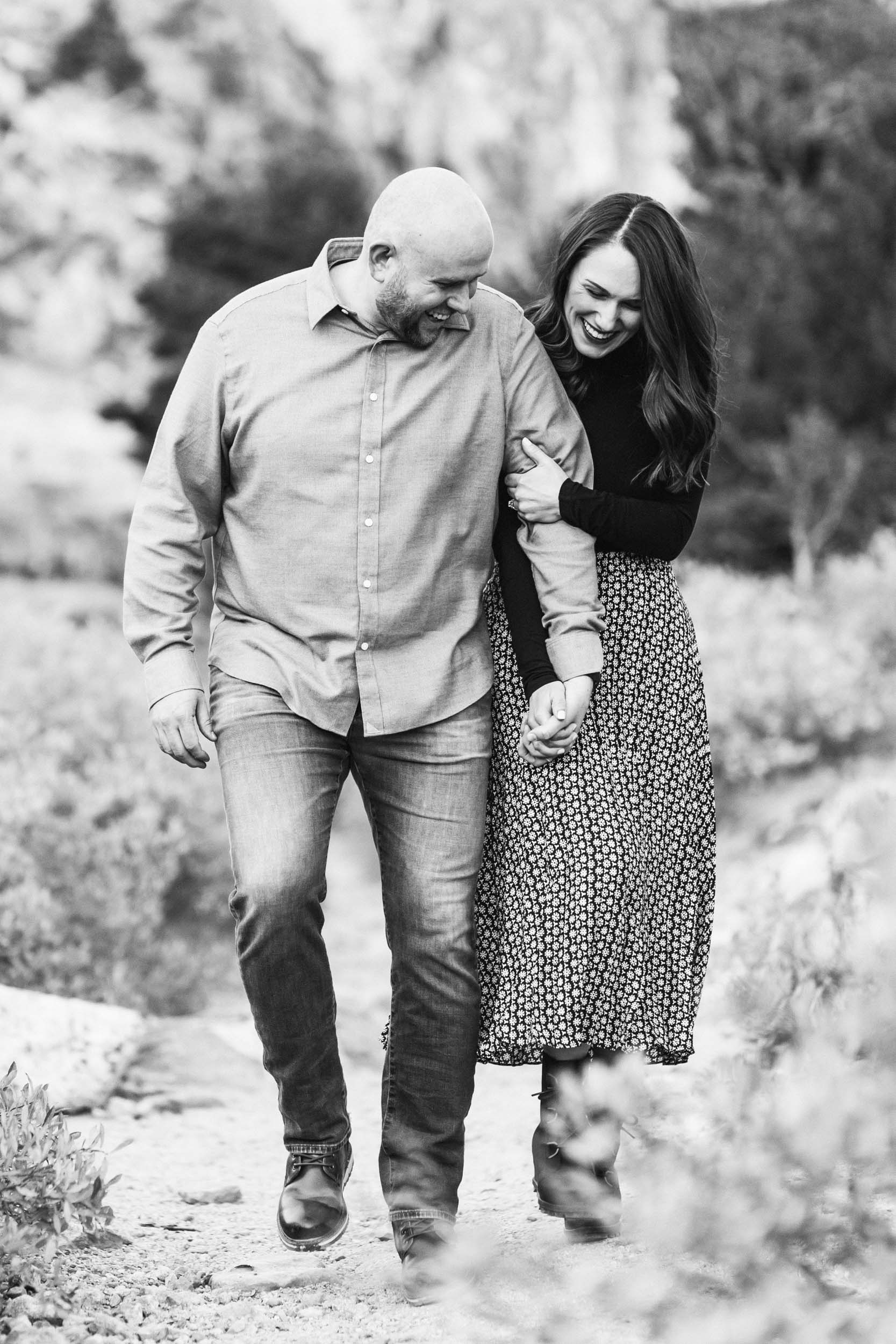 black and white engagement photograph of couple walking and laughing