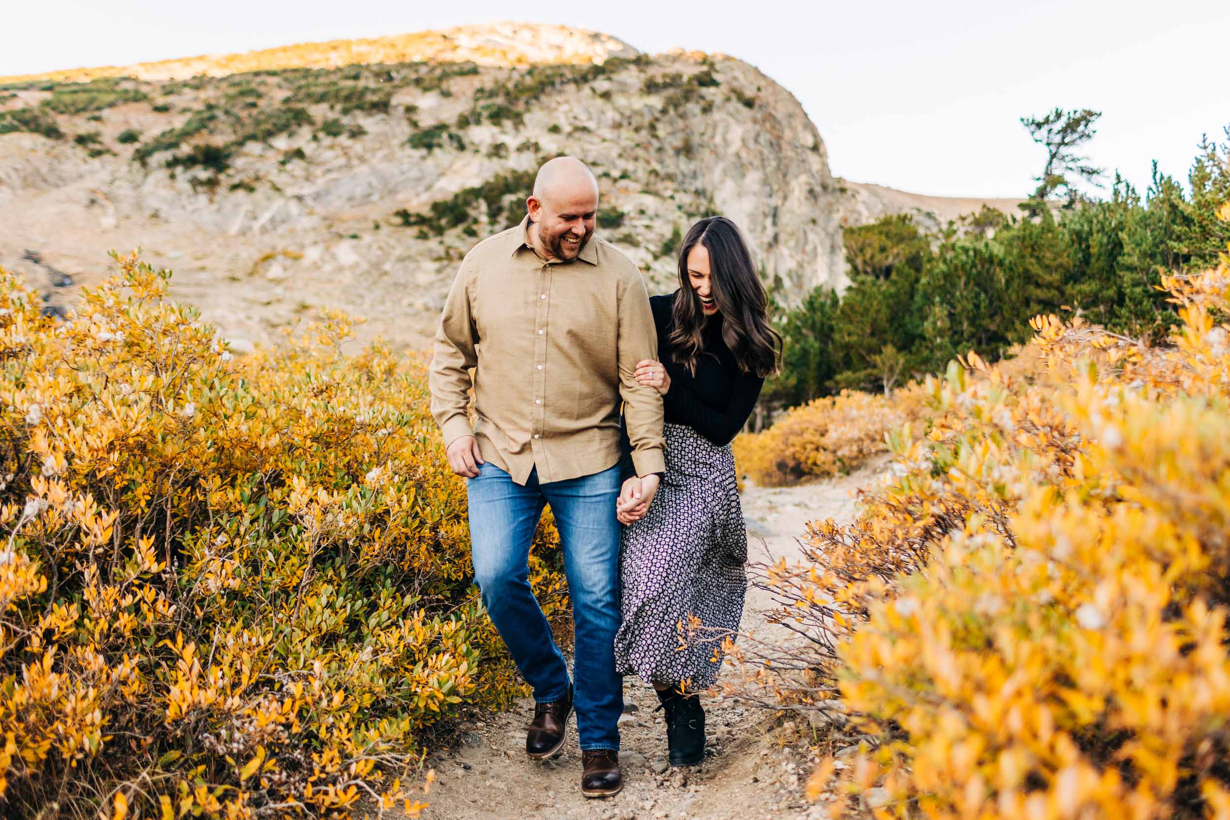 fall engagement photograph of couple walking and laughing