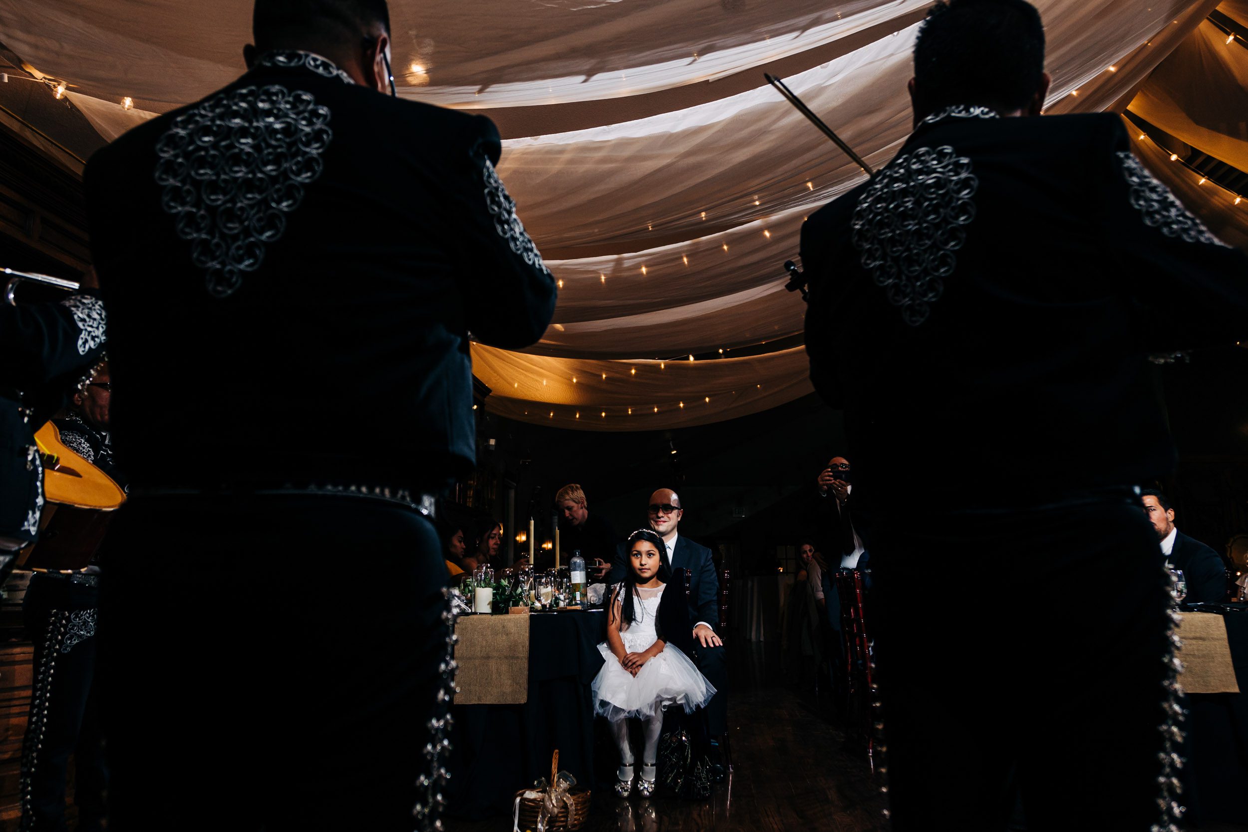 little girl watching mariachi band play at wedding reception