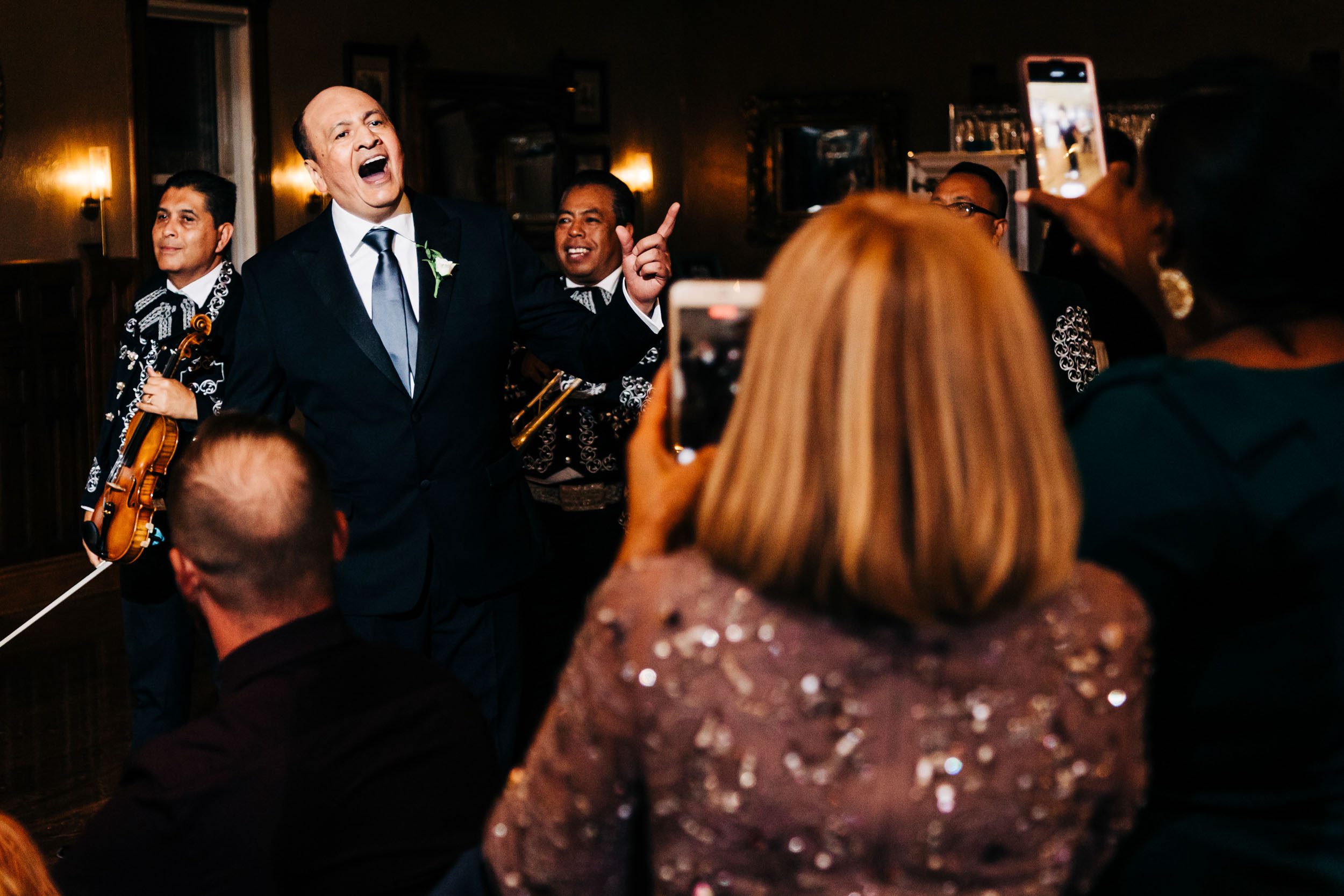 father of the bride singing along with mariachi band at wedding reception