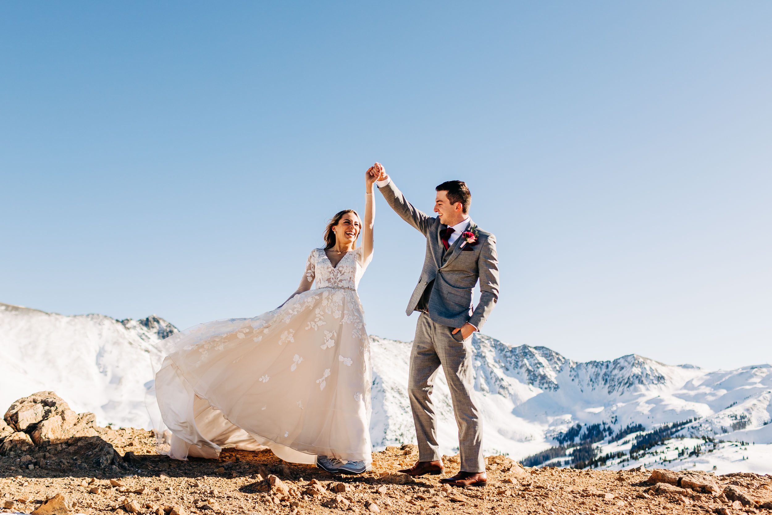 wedding couple twirling at the top of loveland pass