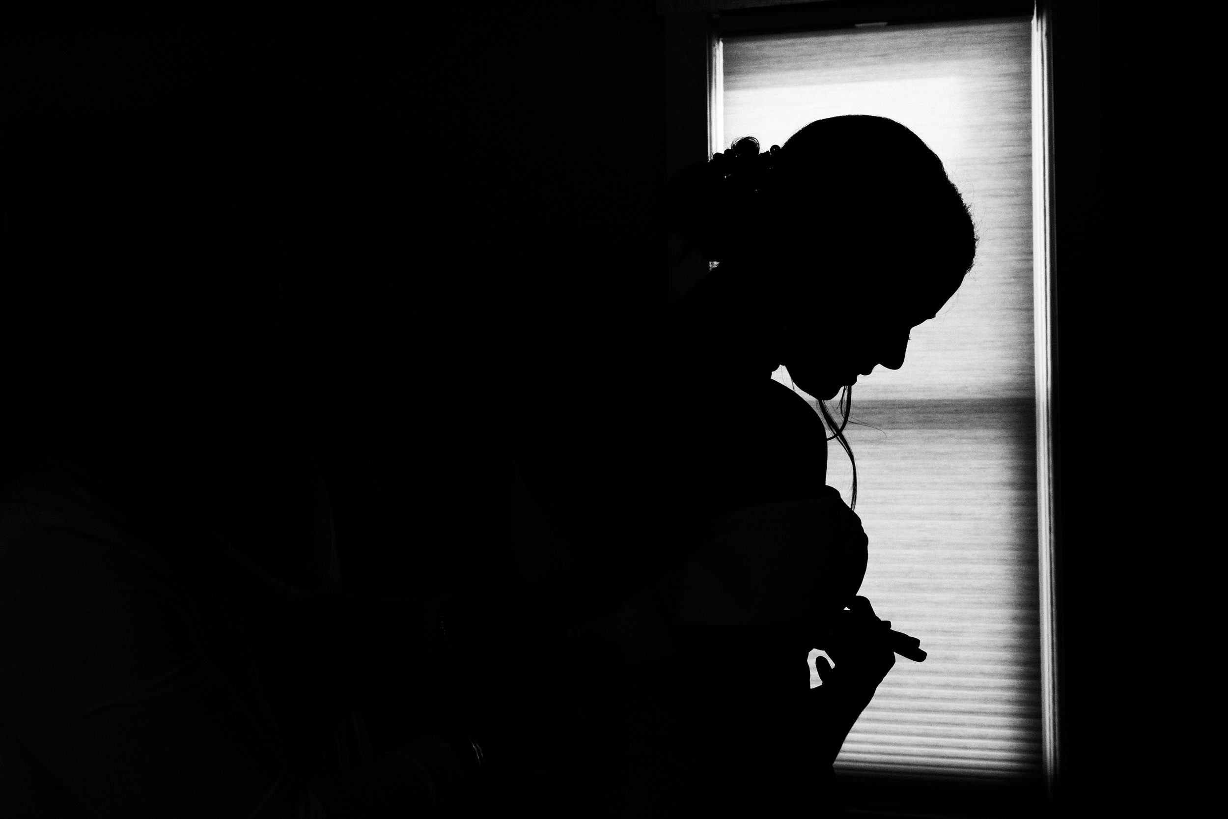 silhouette of bride getting dressed