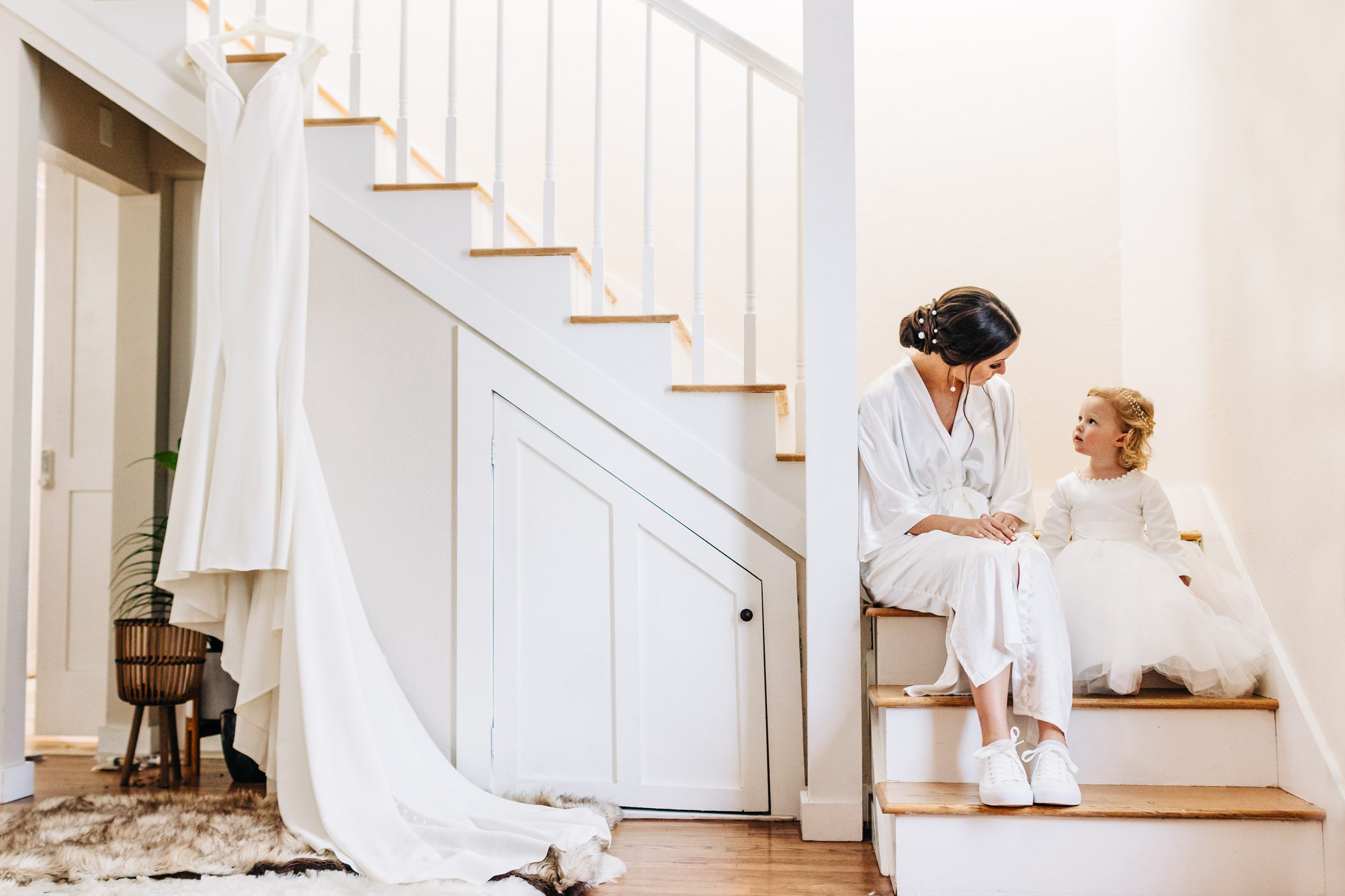 bride and flower girl talking on the stairs