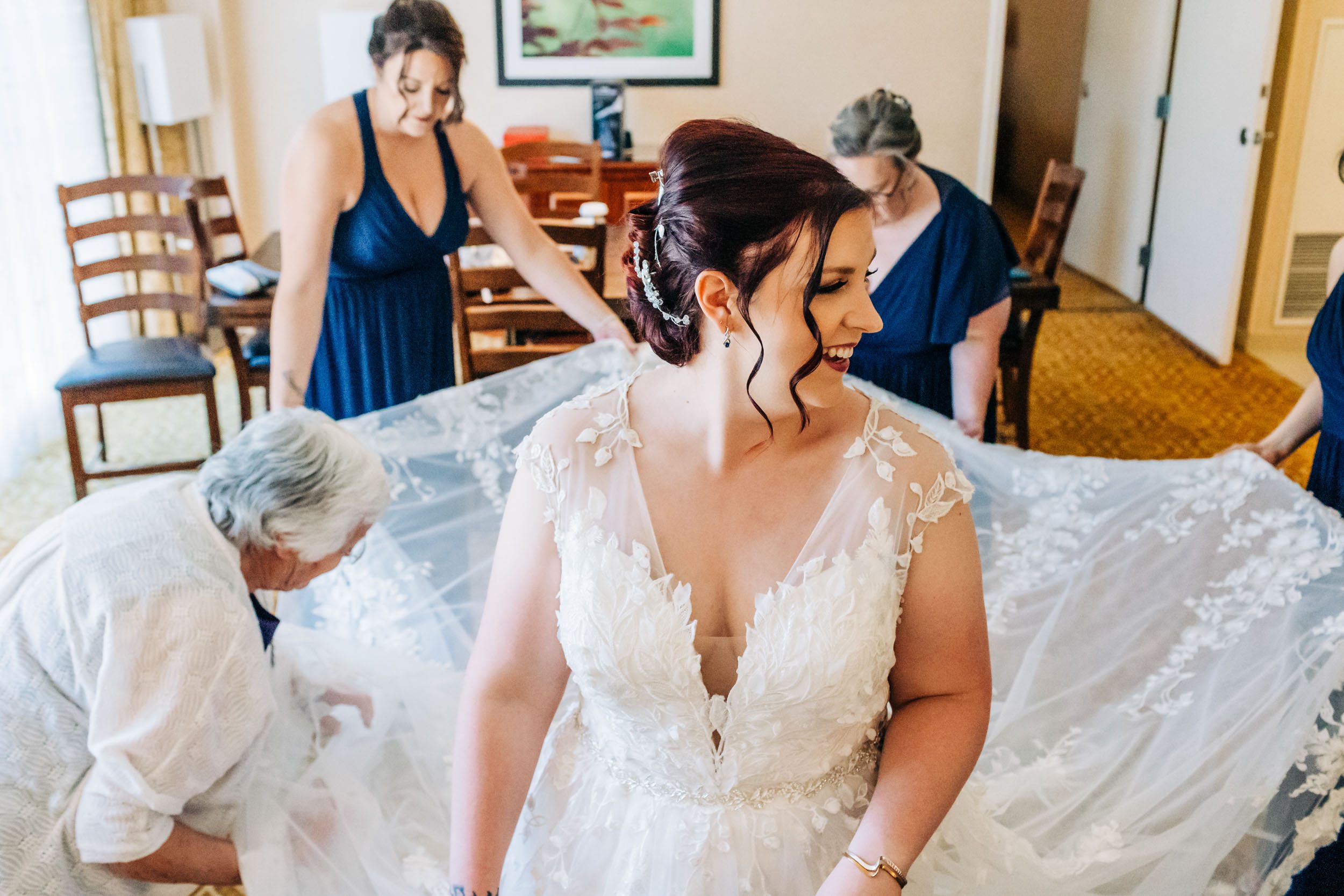 bridesmaids helping bride with wedding dress