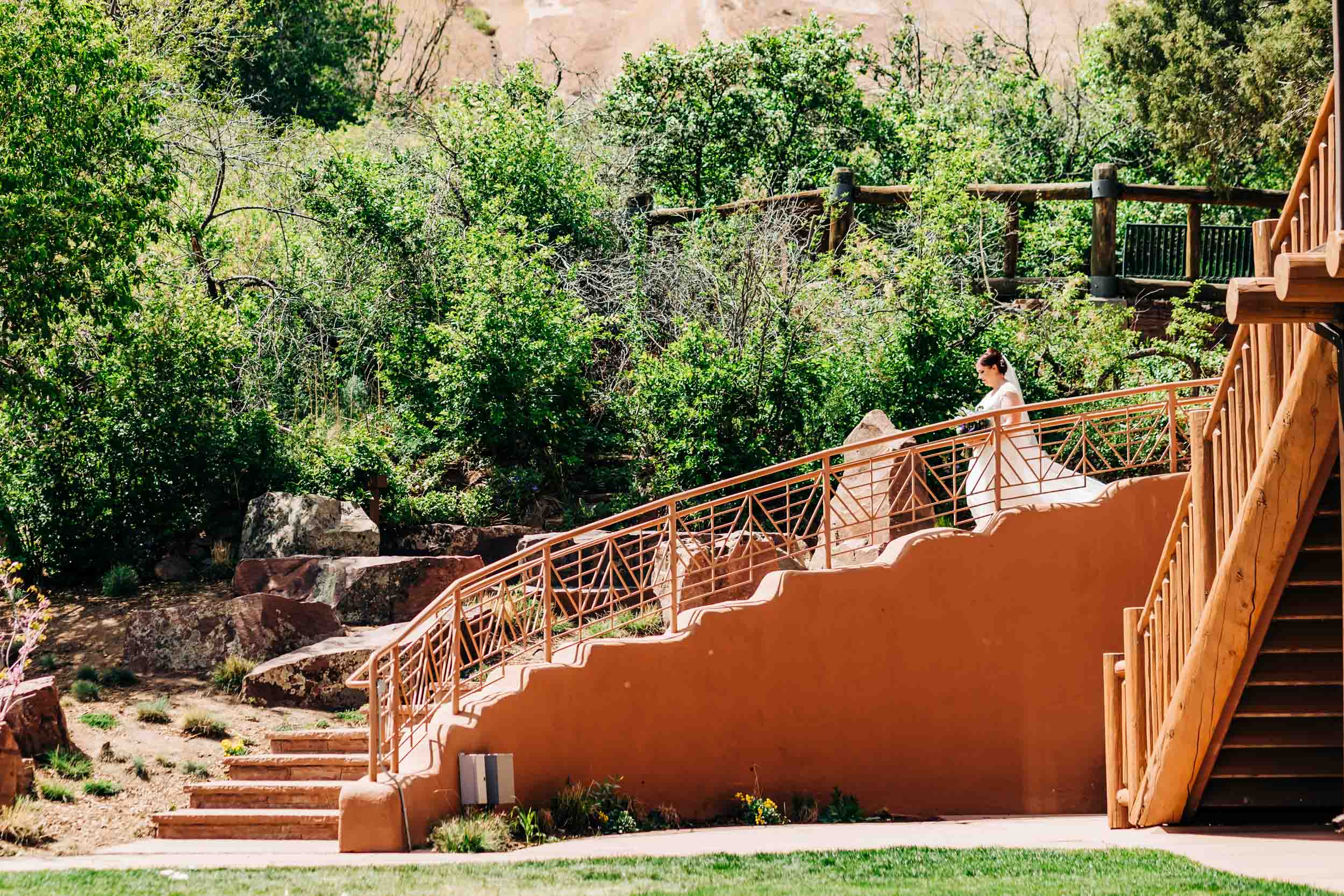 bride walking down stairs to aisle at red rocks trading post wedding