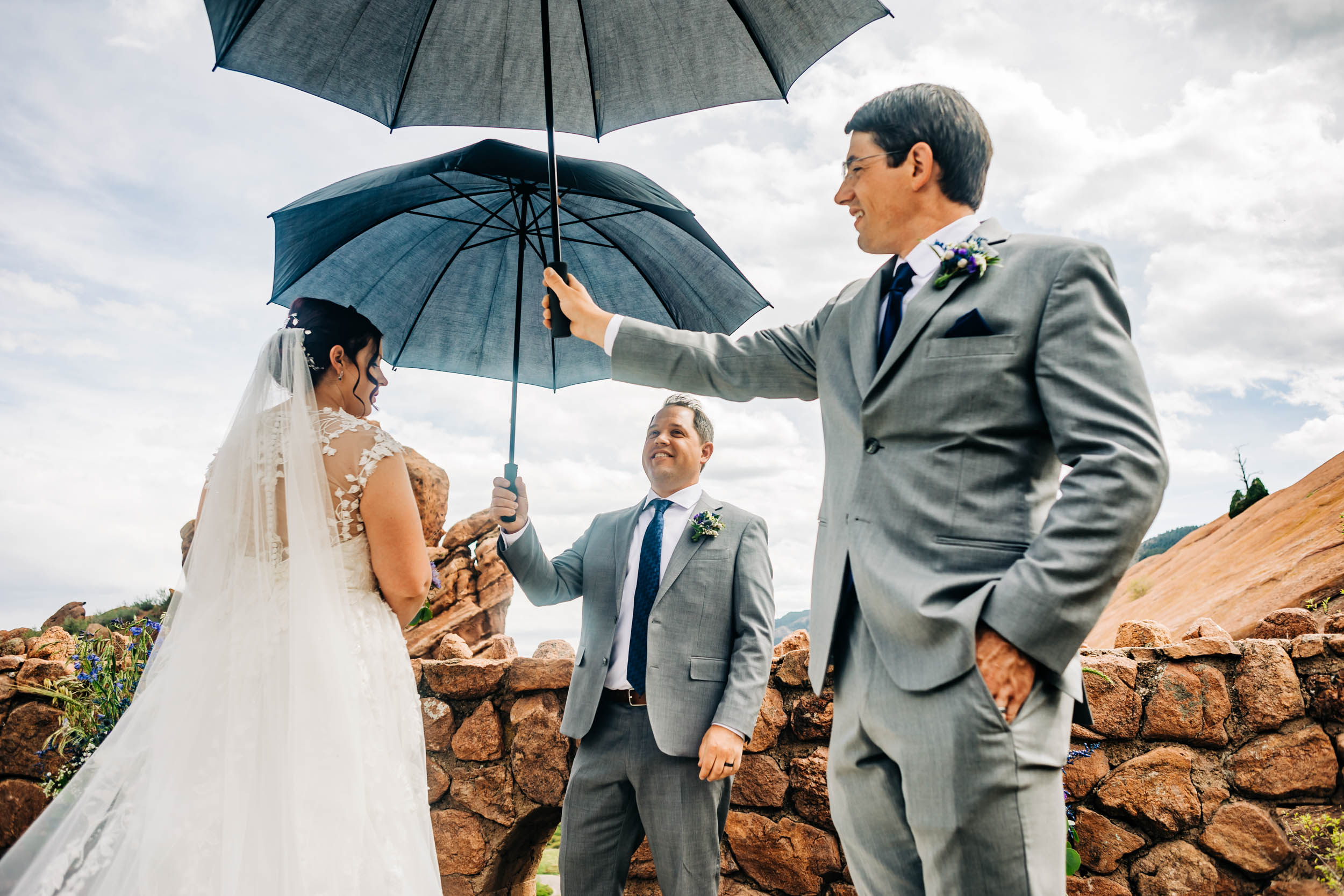 groomsmen holding umbrellas for bride