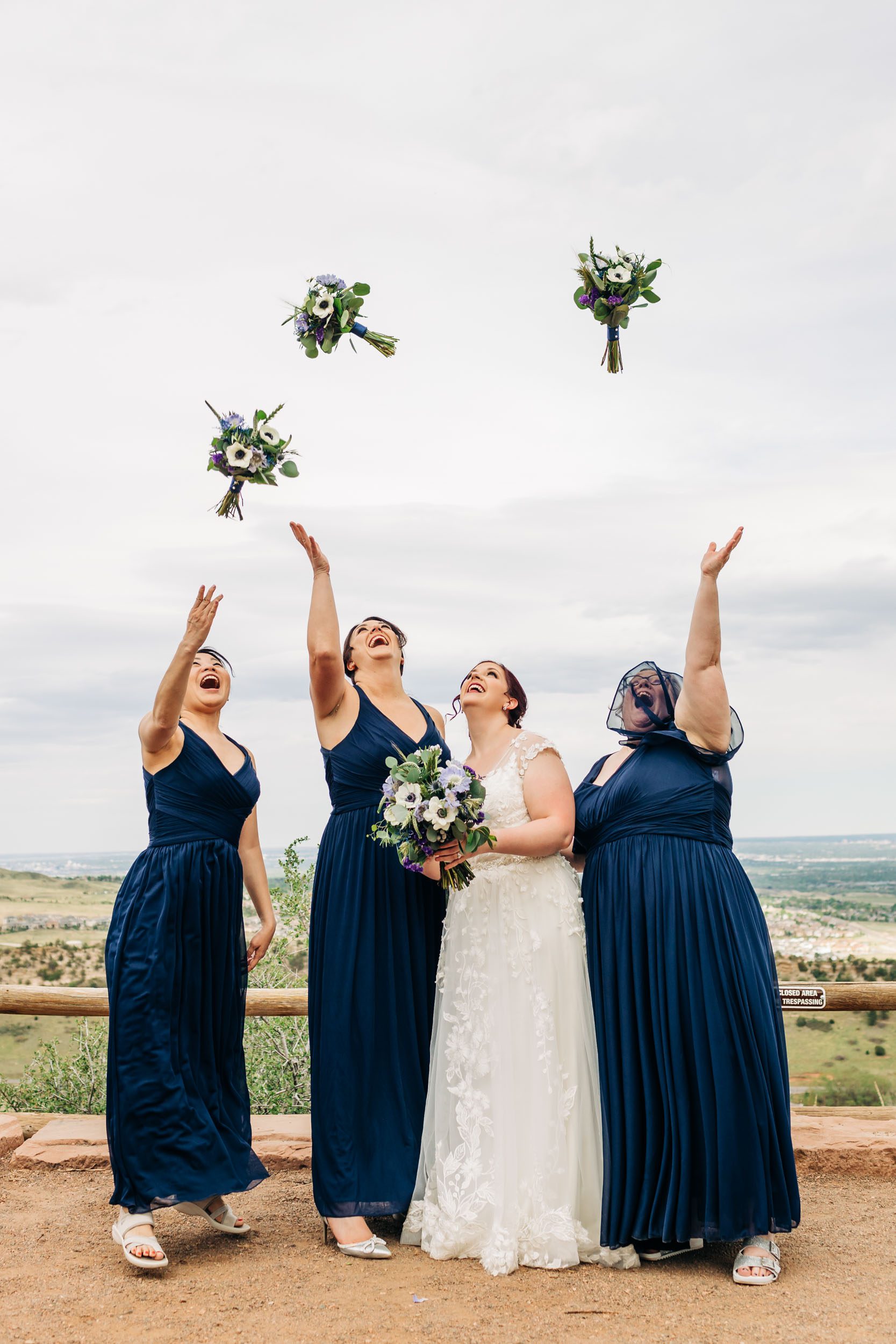 bridesmaids throwing their bouquets at red rocks wedding