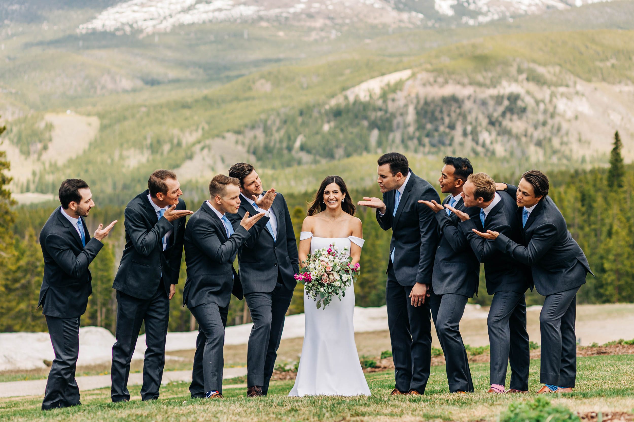 fun wedding party photo of groomsmen blowing kisses to bride