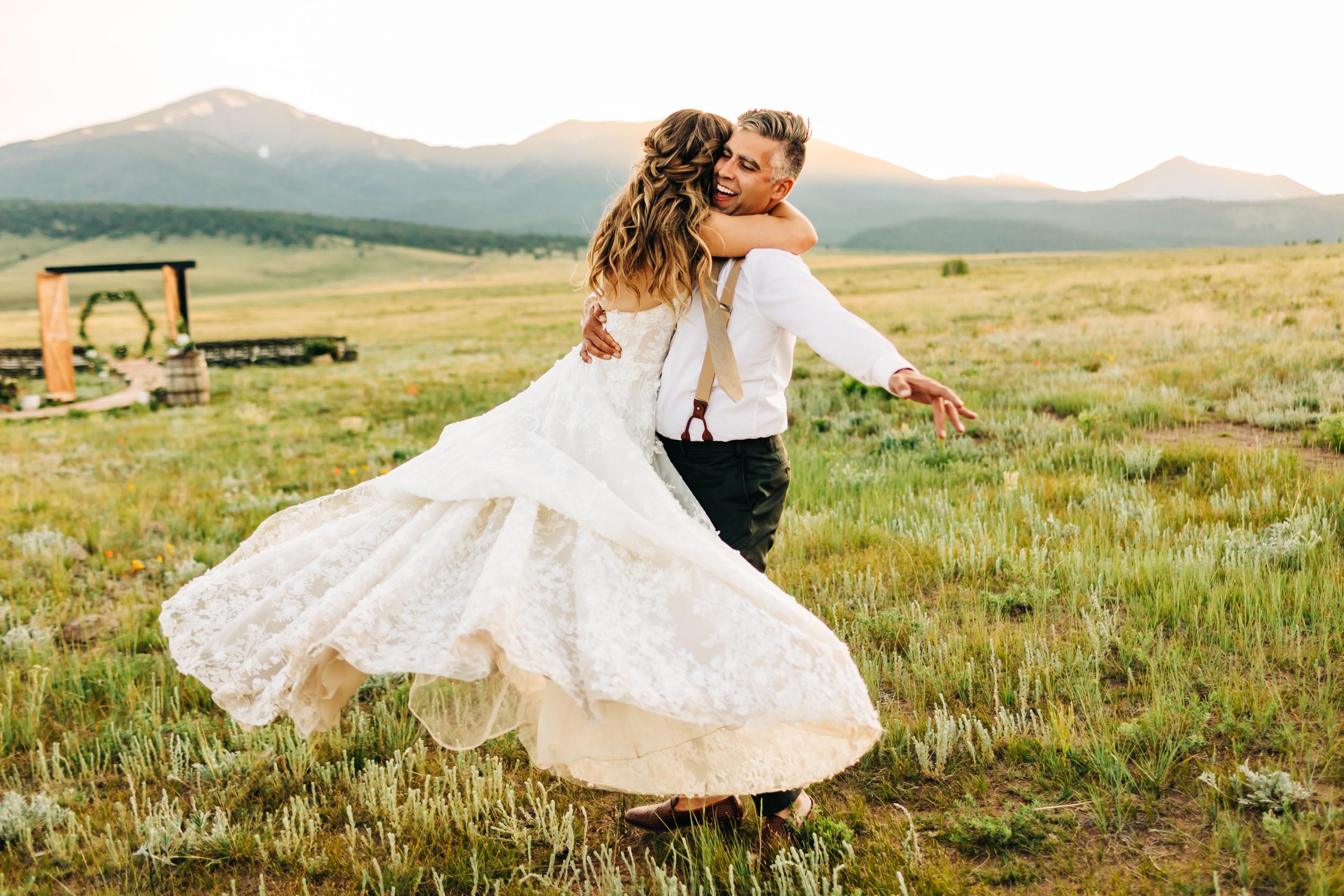 Wedding couple spinning around at sunset