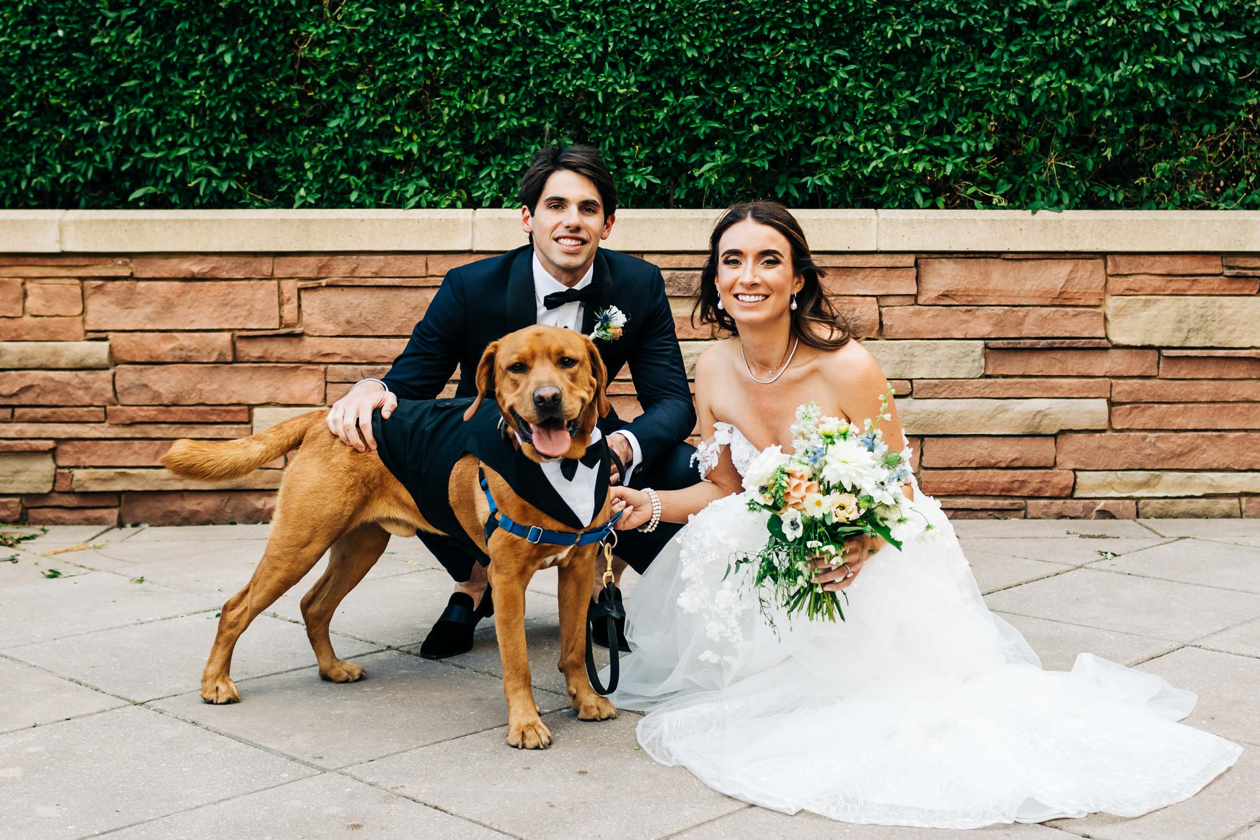 Wedding couple taking picture with their dog
