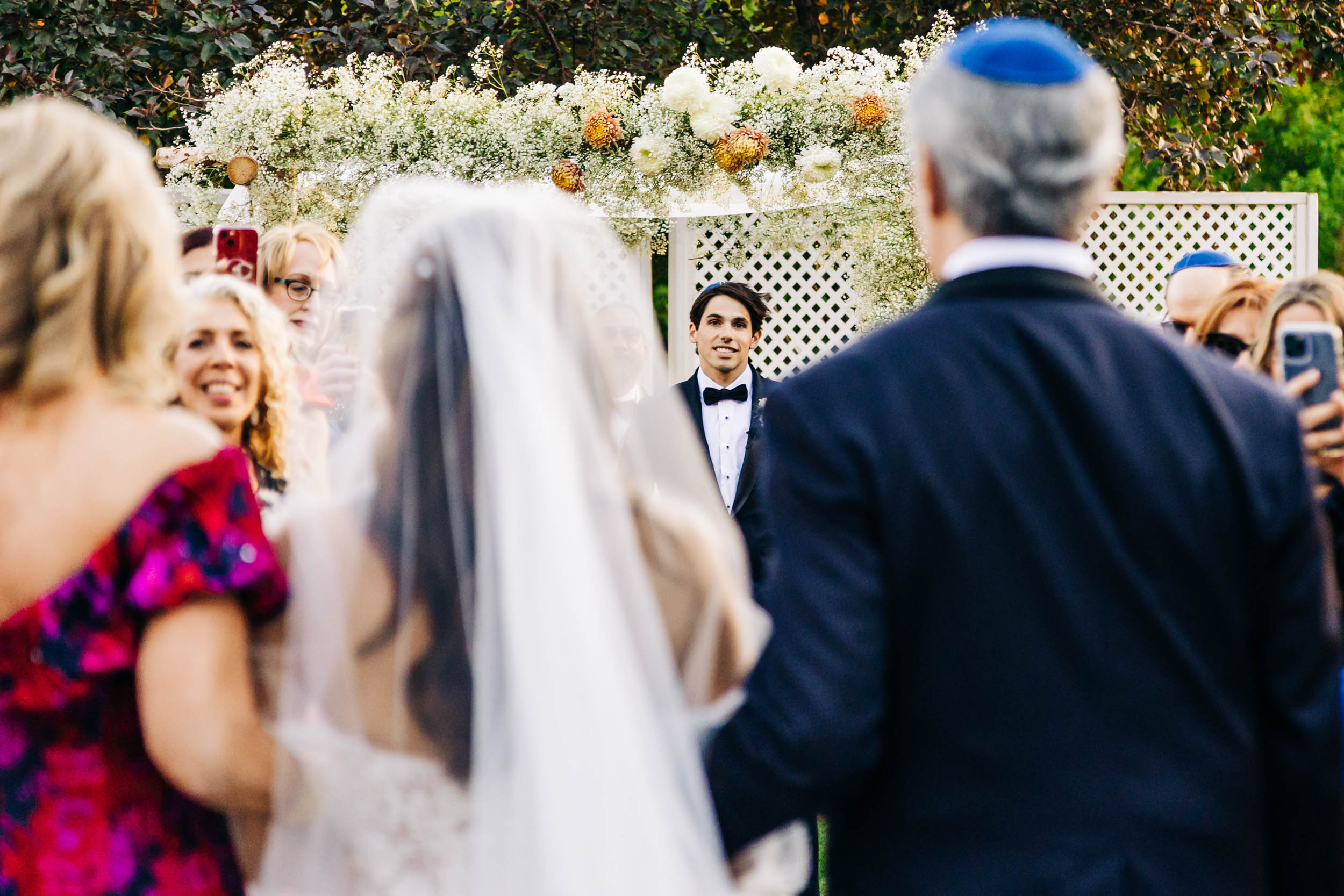 groom watching bride walk down aisle